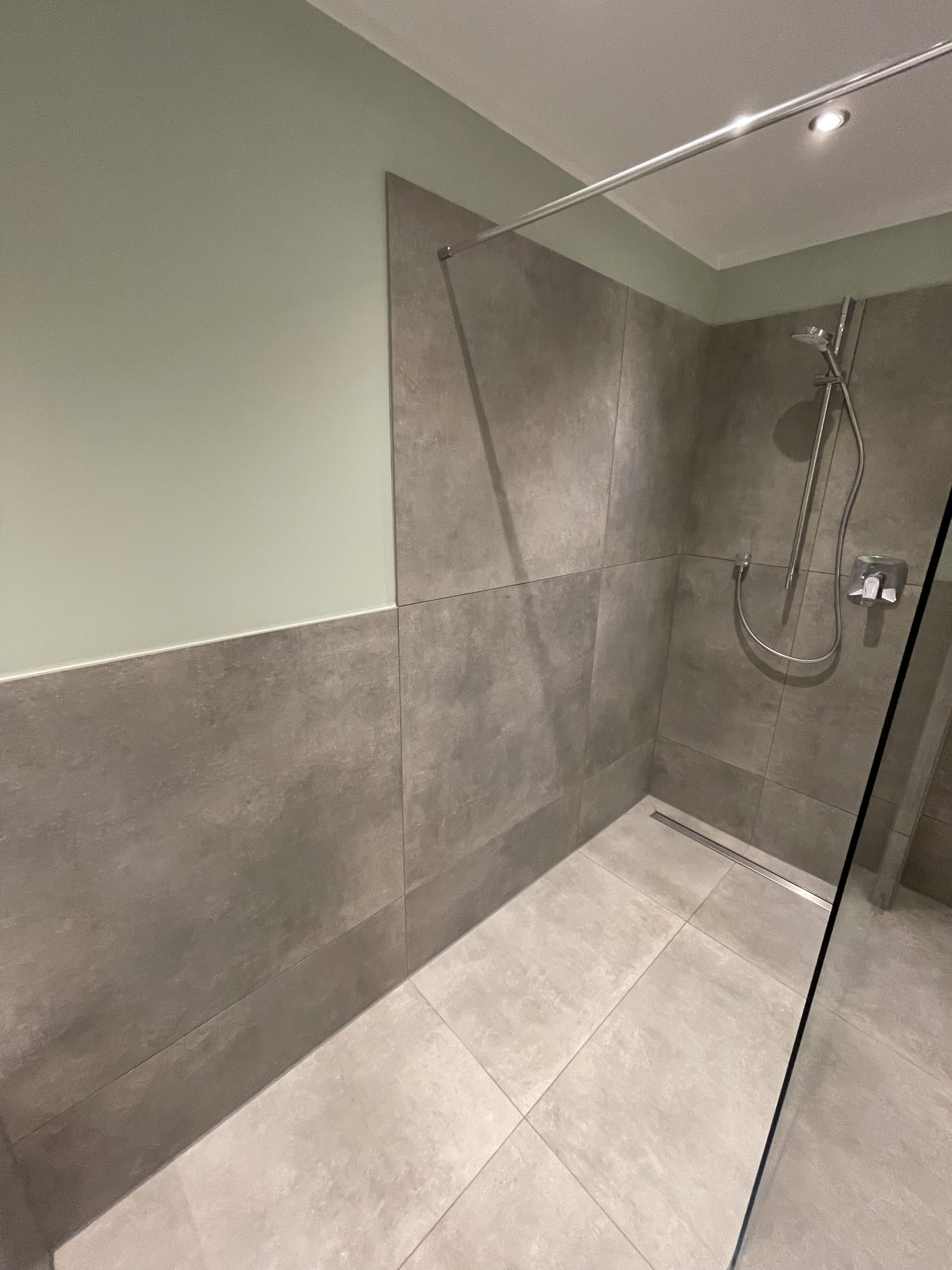 Bodengleiche Dusche mit Fliesen und Bodenablauf nach barrierefreier Badsanierung in Köln